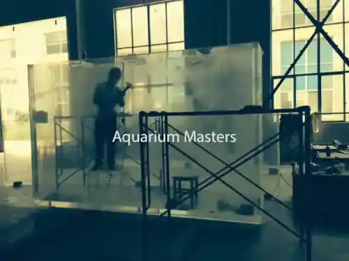 A man working on an acrylic aquarium